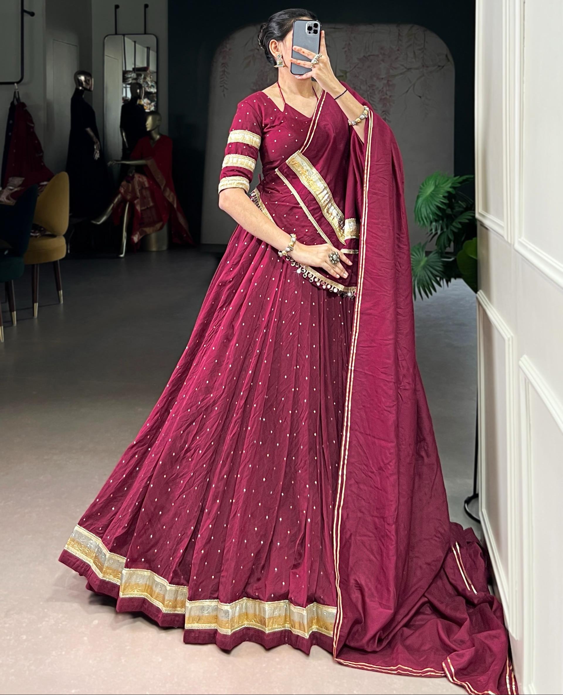 Woman wearing a maroon saree with gold border in an indoor setting