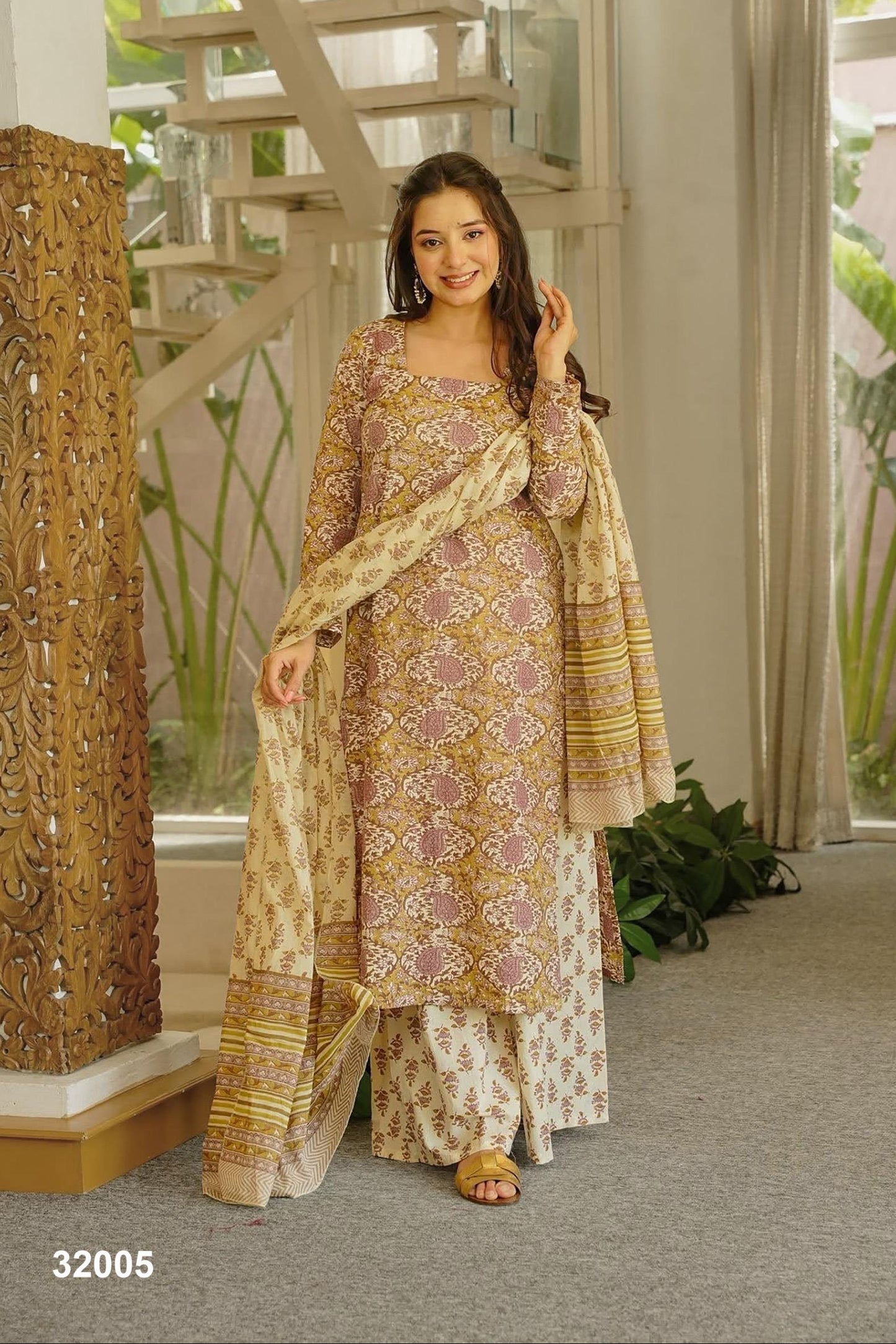 Woman in a traditional outfit standing indoors with decorative elements.