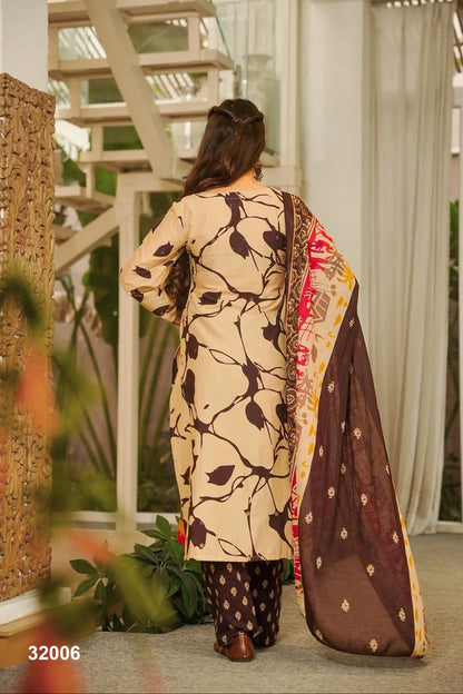 Woman wearing a traditional outfit with a patterned dress and dupatta in an outdoor setting.