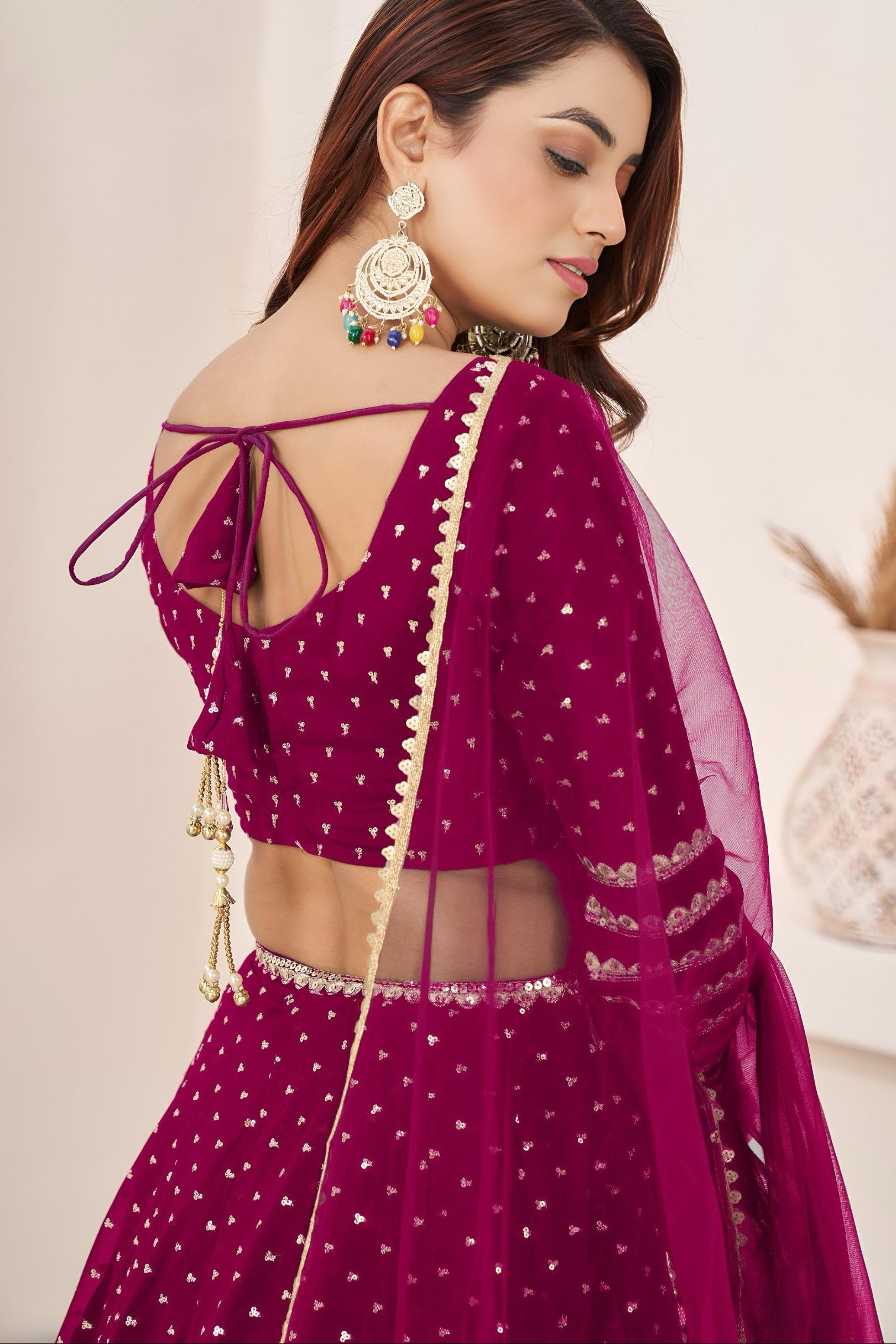 Woman wearing a vibrant purple traditional outfit with intricate designs.
