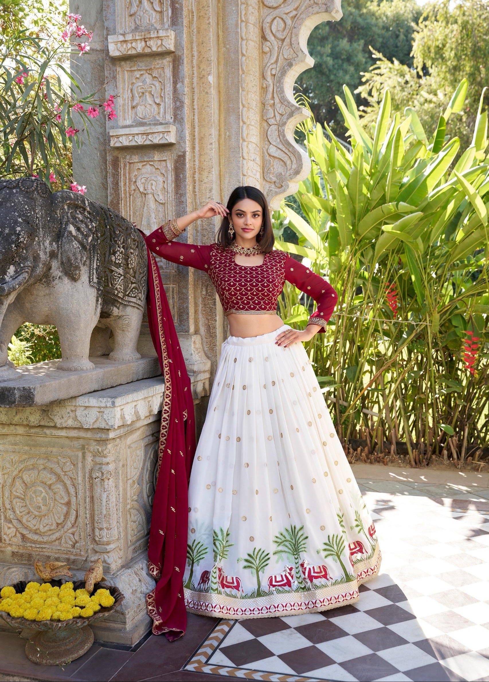 Woman in traditional red and white outfit standing in a garden setting