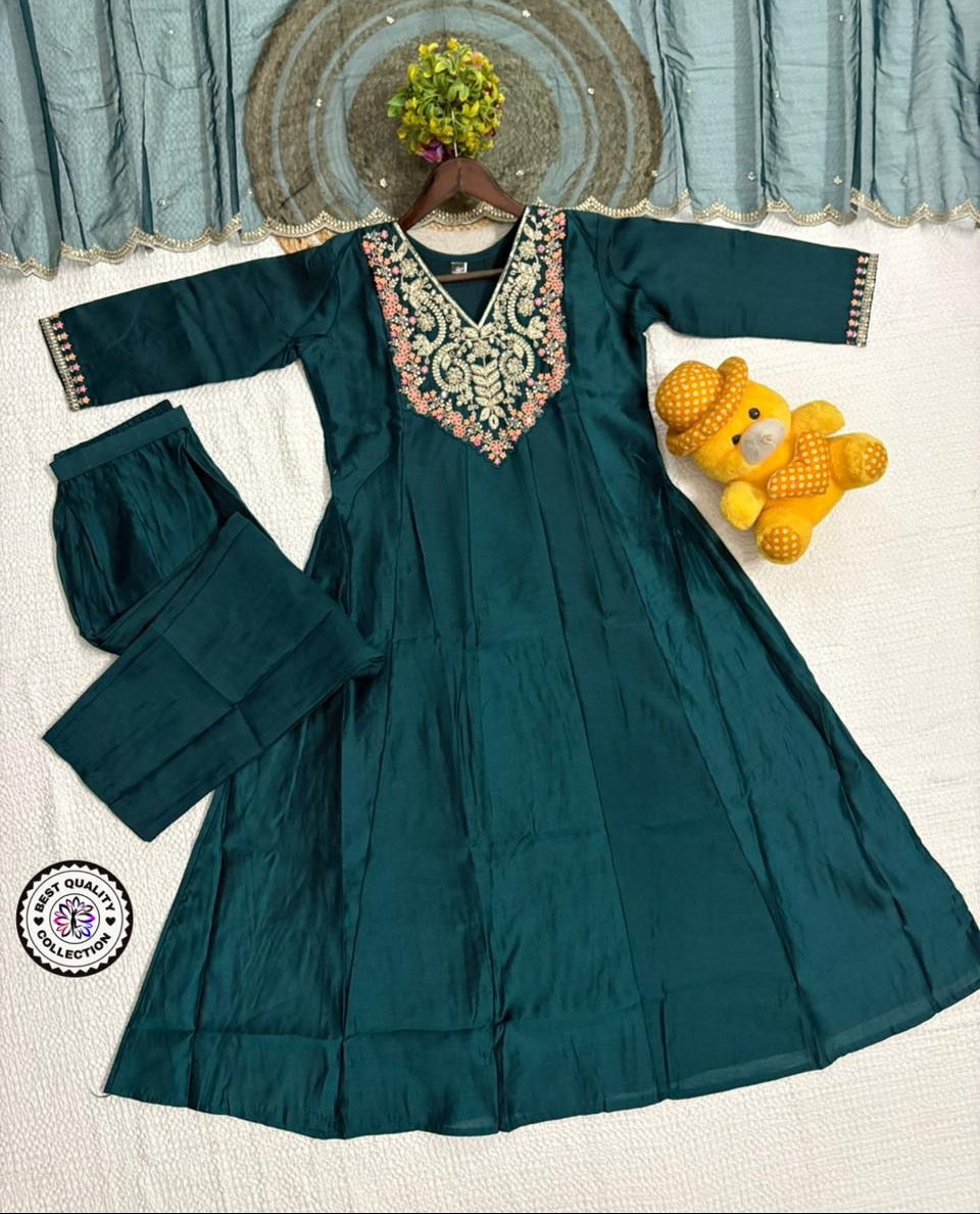 Teal dress with floral embroidery on a white background