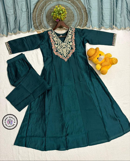 Teal dress with floral embroidery on a white background