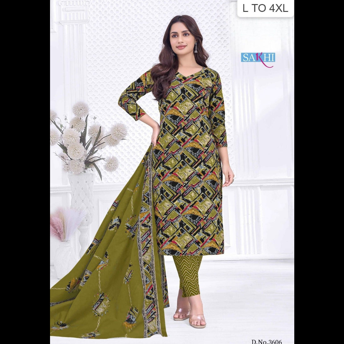 Woman wearing a green and black patterned dress with a matching dupatta, standing against a white wall.