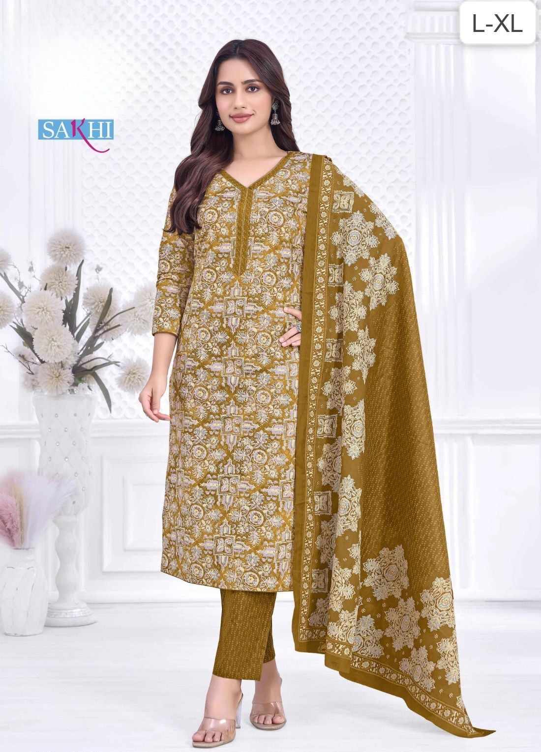 Woman wearing a mustard yellow and white patterned suit with dupatta on a white background