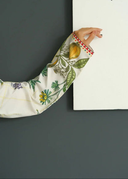 Close-up of a hand wearing a floral sleeve against a dark gray wall. (MARTIVA)