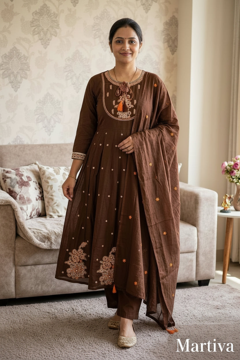 Woman wearing a brown embroidered outfit in a living room setting