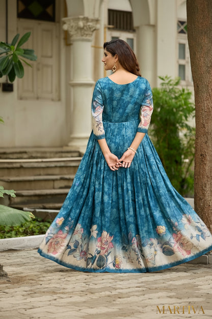 Woman wearing a blue floral dress standing in front of a building with greenery.
