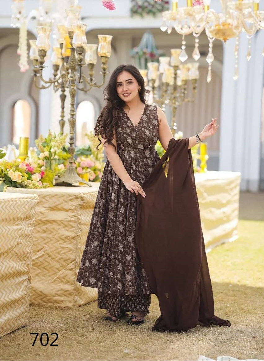 Woman in a floral dress holding a long brown fabric in an elegant indoor setting with chandeliers.