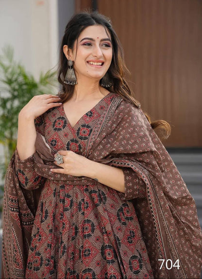 Woman wearing a patterned brown dress with a blurred indoor background