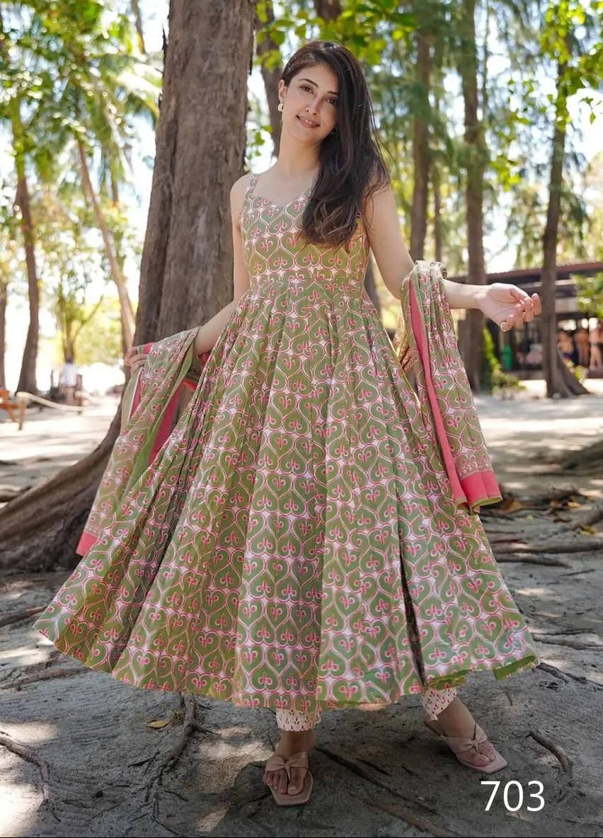 Woman in a patterned dress standing outdoors with trees in the background