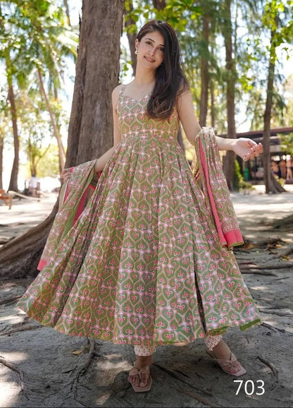 Woman in a patterned dress standing outdoors with trees in the background