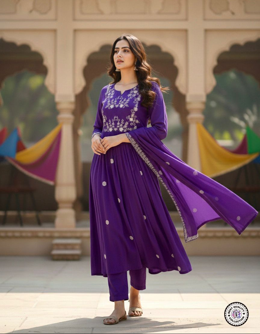 Woman in a purple traditional outfit standing in front of decorative arches.