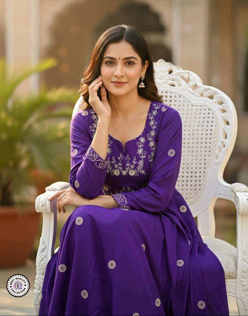 Woman in a purple traditional outfit sitting on a white chair outdoors.