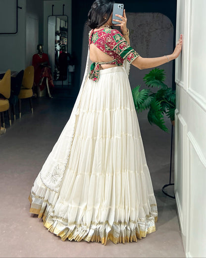 Woman taking a mirror selfie wearing a traditional outfit with a colorful blouse and white skirt.
