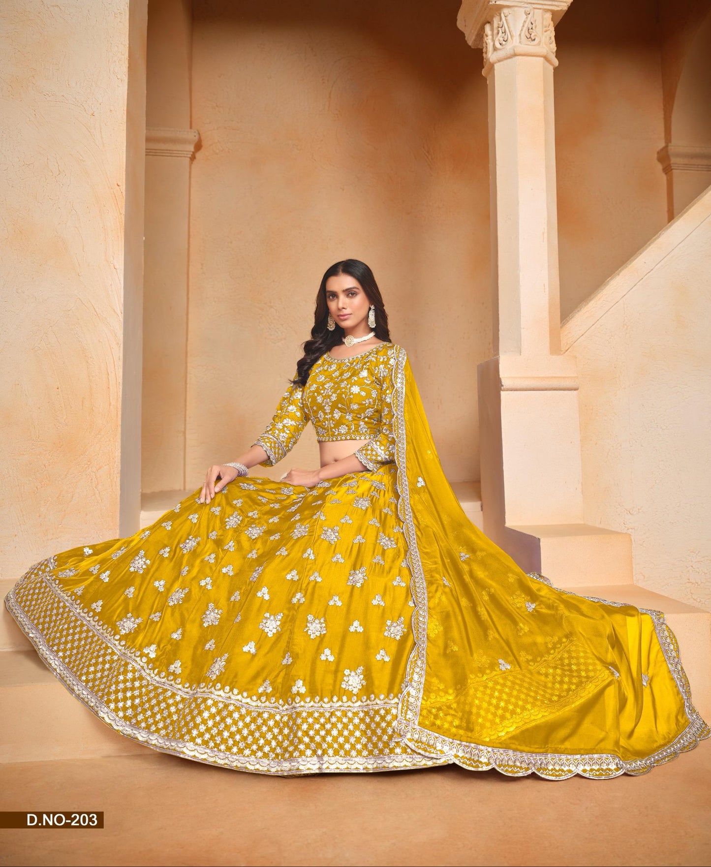 Woman in a yellow traditional outfit with intricate patterns sitting in an architectural setting.