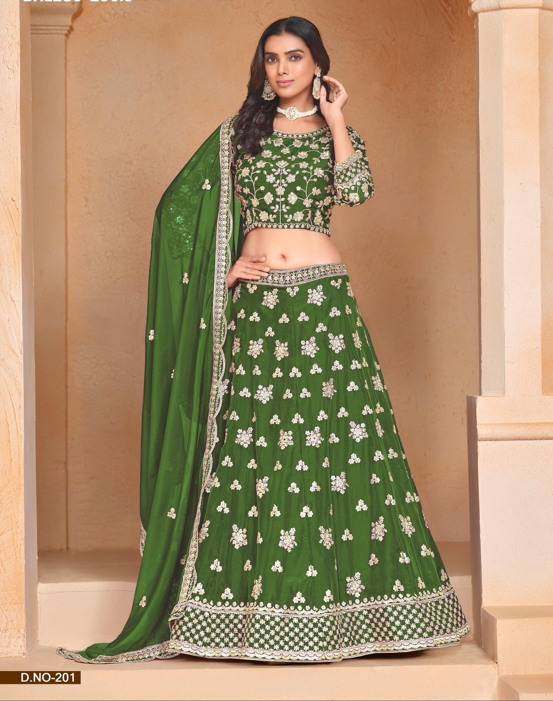 Woman wearing a green traditional outfit with floral patterns in an indoor setting.