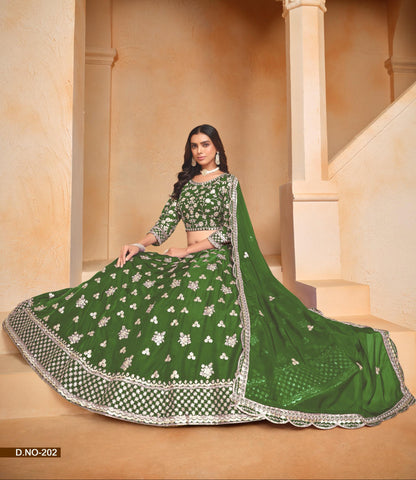 Woman in a green traditional outfit with silver embroidery sitting in an architectural setting.