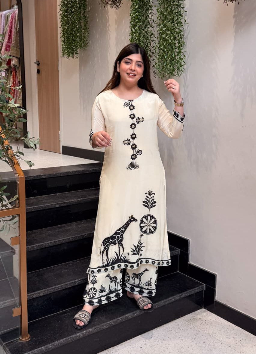 Woman in a white traditional outfit with black patterns standing on a staircase.