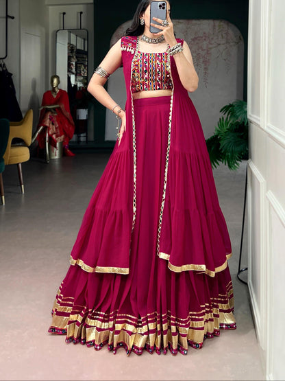 Person wearing a vibrant red traditional outfit with gold details in a room setting.