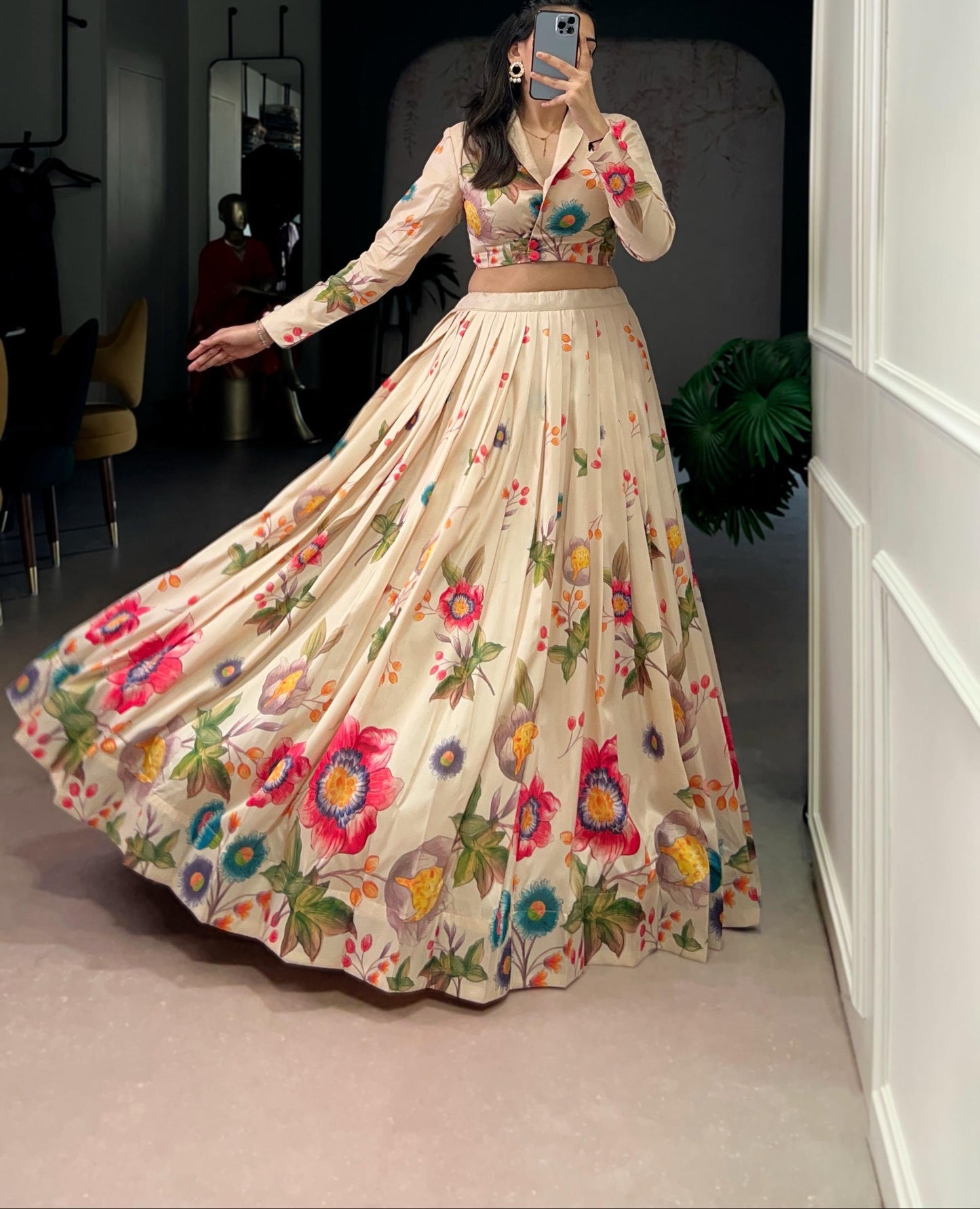 Person wearing a floral embroidered outfit taking a mirror selfie.