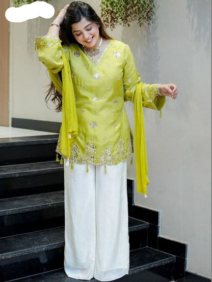 Woman in a yellow embroidered outfit standing on stairs